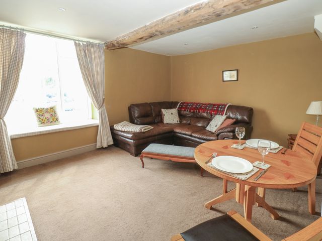 A living room with a sofa and dining table at Ewe Cottage in Masham