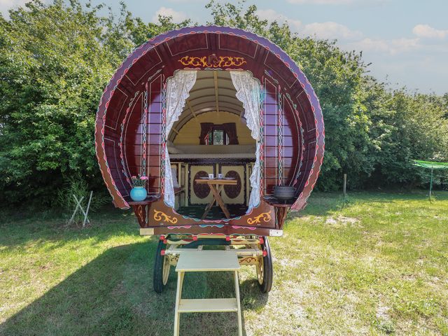 A gypsy caravan with a table and chairs outside at The Bowtop Gypsy Caravan in Eye