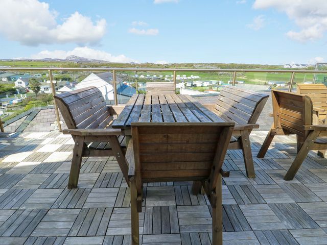 An outdoor patio with wooden furniture at 19 Cliff Apartments in Trearddur Bay