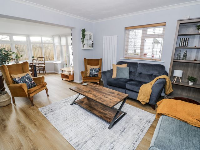 A living room with a sofa, coffee table, and armchairs at 3 Leycester Court in Warwick