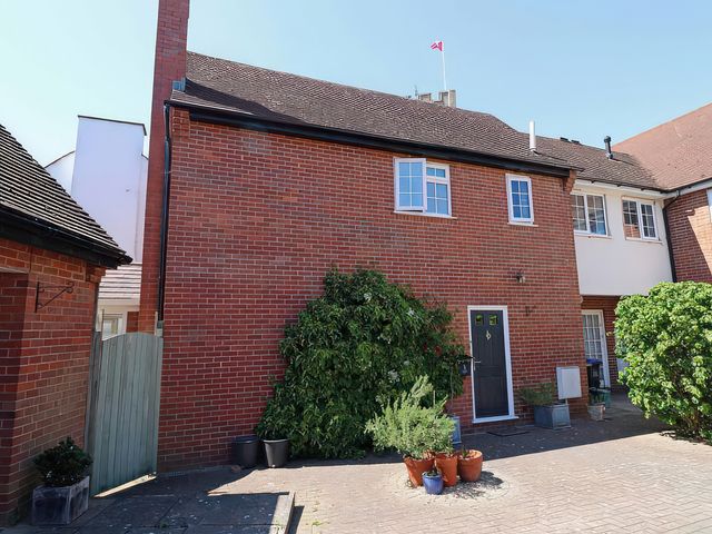 A house exterior with a brick wall and plants at 3 Leycester Court in Warwick