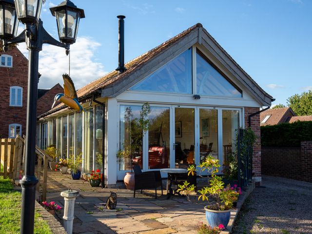 A garden with plants and glass doors at Nature's Lodge in Kidderminster