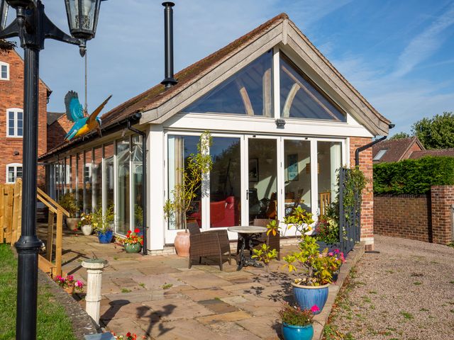 A conservatory with glass walls and plants outside at Nature's Lodge in Kidderminster