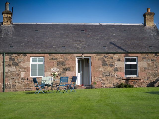 A house with a table and chairs in the garden at The Bothy in Blairgowrie