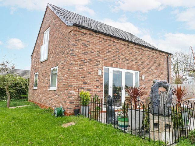A garden with a brick wall house and a water feature at The Retreat 