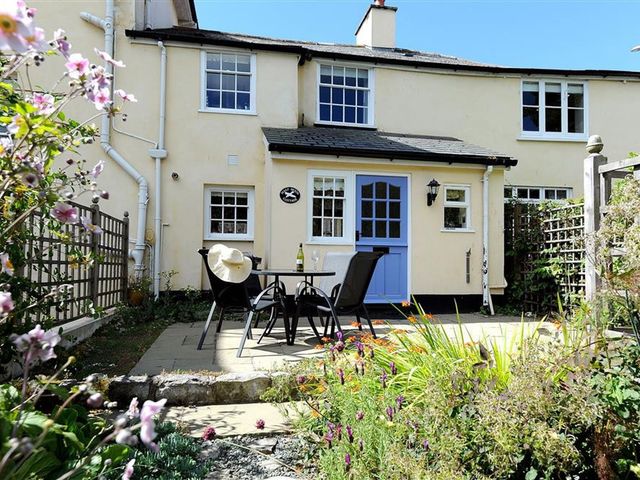 An outdoor seating area with a table and chairs at Half Moon Cottage in Lyme Regis