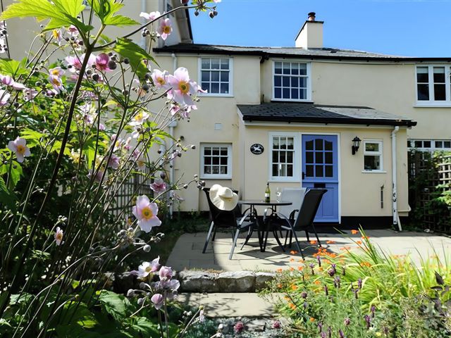A garden with table and chairs at Half Moon Cottage in Lyme Regis