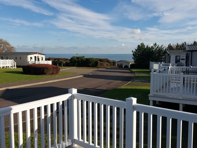 View from a deck overlooking holiday homes and the sea at Devon Cliffs Holiday Park - Holiday Accommodation 13607, Exmouth