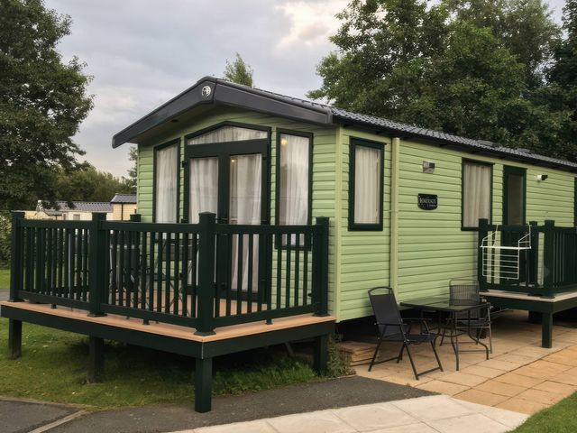 A holiday home with a deck and chairs at Hafan y Mor Haven - Holiday Accommodation 1444 Pwllheli