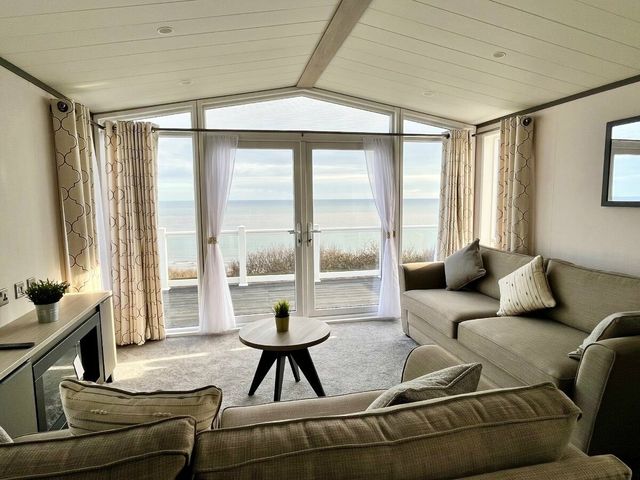 a living room with a view of the sea at Devon Cliffs Holiday Park - Holiday Accommodation 14661 in Exmouth