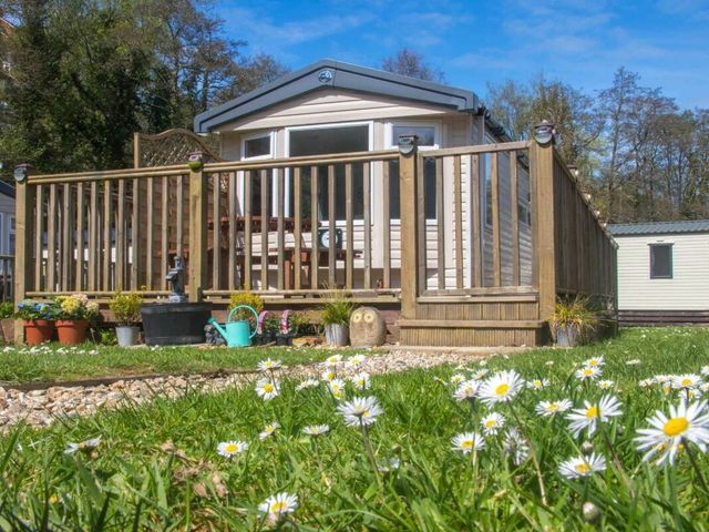a holiday home with a deck and plants at Hele Valley Holiday Park - Holiday Accommodation 15137 in Ilfracombe