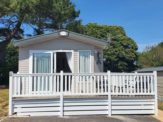 a vacation home with a deck and large front windows at Shorefield Country Park - Holiday Accommodation 15558 Milford On Sea