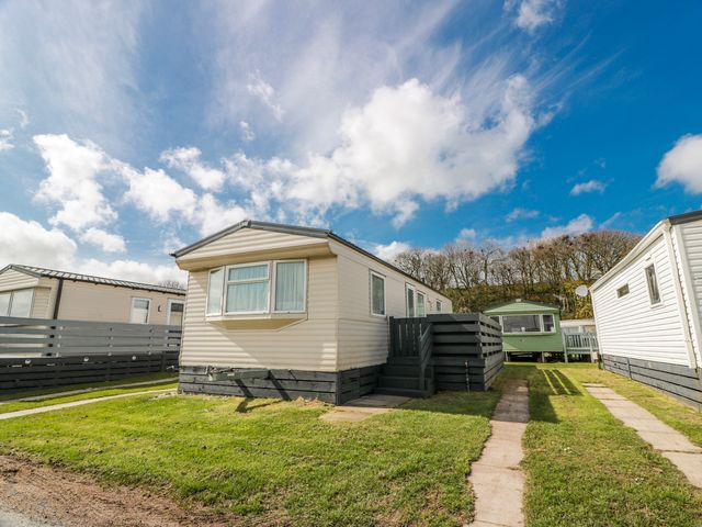 A caravan with steps and lawn at WigBay Holiday Park - Holiday Accommodation 16774 Stranraer