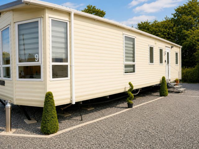 A mobile home with windows and steps at Marsh Farm Holiday Park - Holiday Accommodation 17738, Great Yarmouth