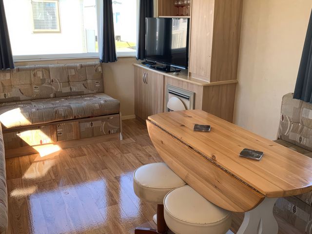 A living room with a sofa and a television at Whitehouse Leisure Park - Holiday Accommodation 18340, Towyn