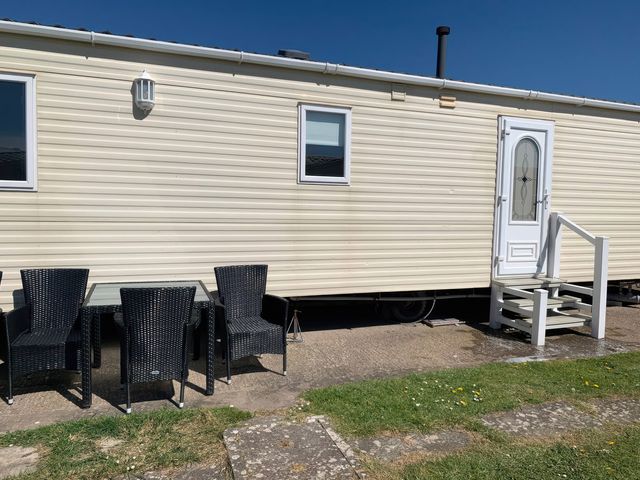 A mobile home with outdoor seating at Whitehouse Leisure Park - Holiday Accommodation 18340 Towyn