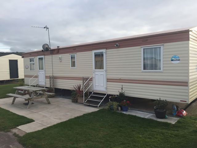 A mobile home with a picnic table at Presthaven Beach Resort - Holiday Accommodation 18911 Prestatyn