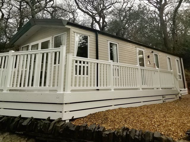 A holiday home with decking and windows at Aberdunant Hall Holiday Park - Holiday Accommodation 19035, Porthmadog
