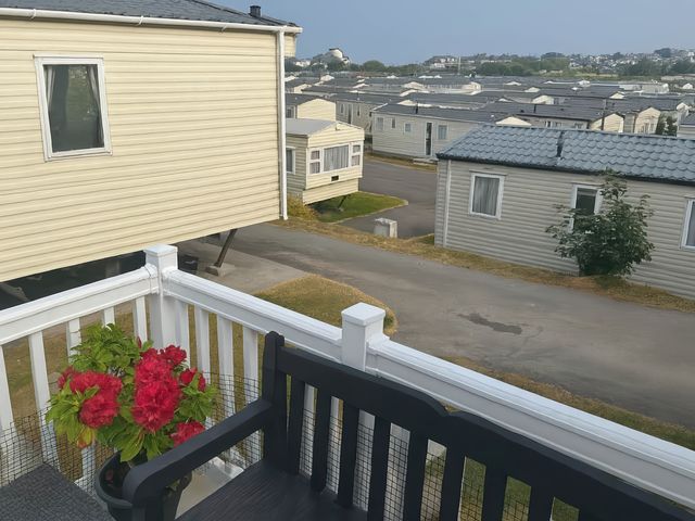 A balcony view with a flower pot and caravans at Brynowen Holiday Park - Holiday Accommodation 19041 Borth Mis Wales