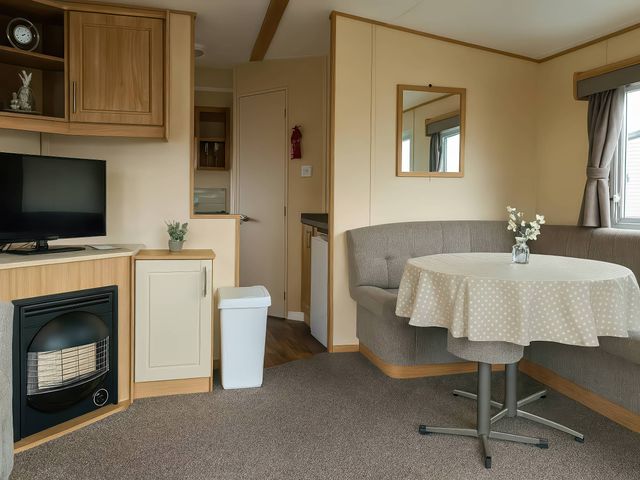 A living room with a television and coffee table at Golden Gate Holiday Centre - Holiday Accommodation 19059 Towyn