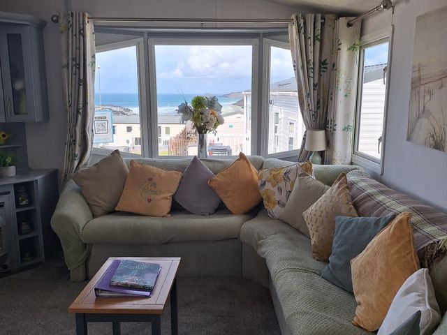 A living room with a sofa and window view at Liskey Hill Caravan Park - Holiday Accommodation 20197 Perranporth