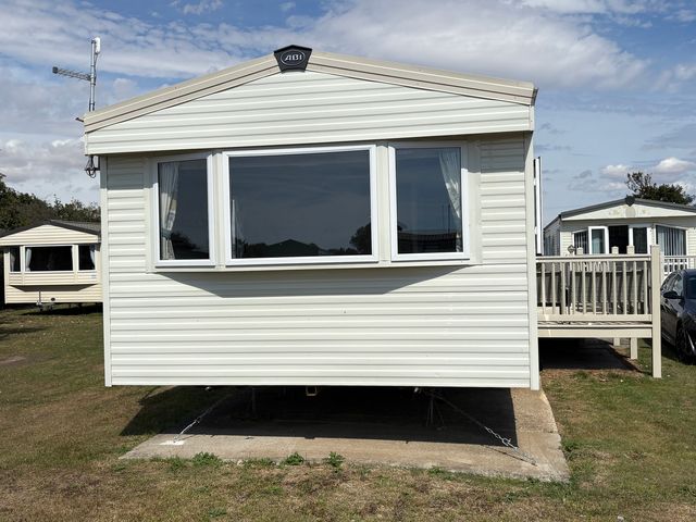 A caravan with a decking area at Skipsea Sands Holiday Park - Holiday Accommodation 20390 Driffield