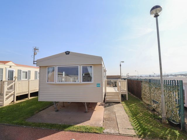 A mobile home with a deck and steps at Golden Sands Kinmel Bay - 20528 Rhyl