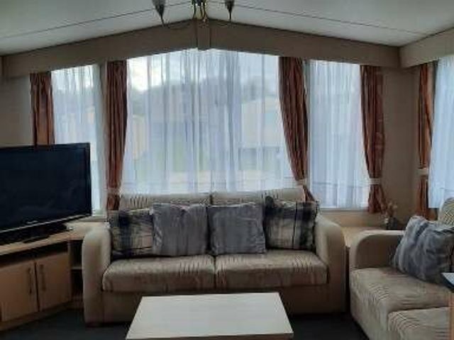 a sitting area with a sofa, coffee table and a television at Happy Days Seaside Holiday Park - Holiday Accommodation 21143 in Mablethorpe