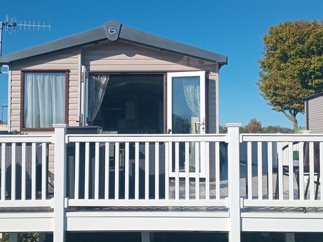 A house with a deck and railings at Primrose Valley Holiday Park - Holiday Accommodation 2533 in Filey