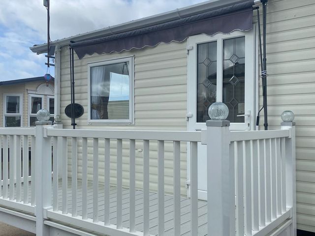 A doorway and windows on a deck at Happy Days Caravan Park - Holiday Accommodation 3599 Towyn