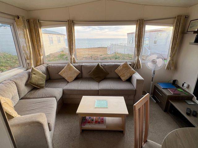 A living room with a sofa and table at Kiln Cliffs Caravan Park - Holiday Accommodation 432 in Mundesley