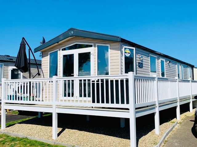 a holiday home with a deck and outdoor seating at Seashore Holiday Park - Holiday Accommodation 848 in Great Yarmouth