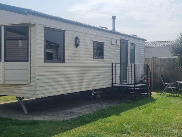 a caravan with steps outside on a lawn at Green Farm Caravan Park - Holiday Accommodation 9807 in Great Yarmouth
