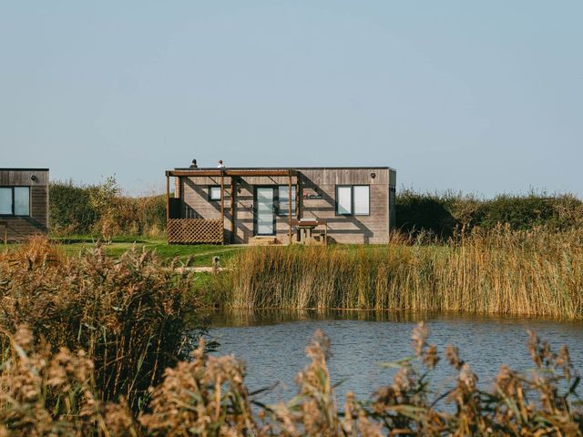 A cabin by a lake with a deck and seating at Lakeside Studio in Portreath