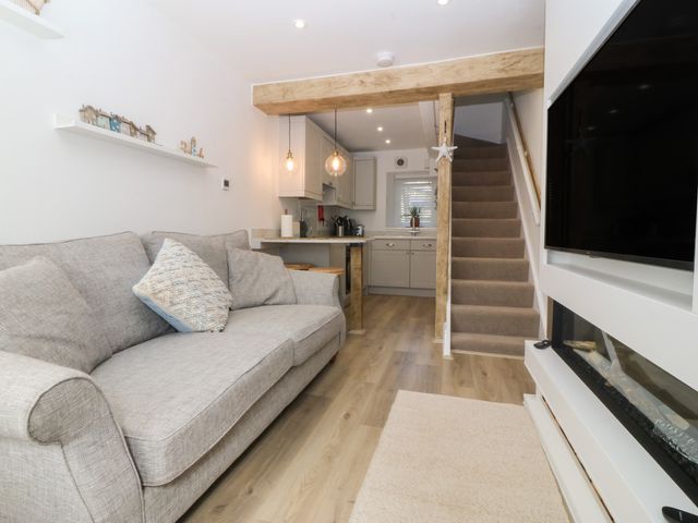 A living room with a sofa and table at 61A High Street in Criccieth