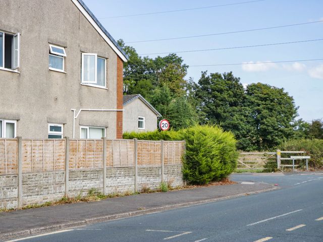 A house with a fence and a speed limit sign near the road at Aqueduct Residence in Lancaster