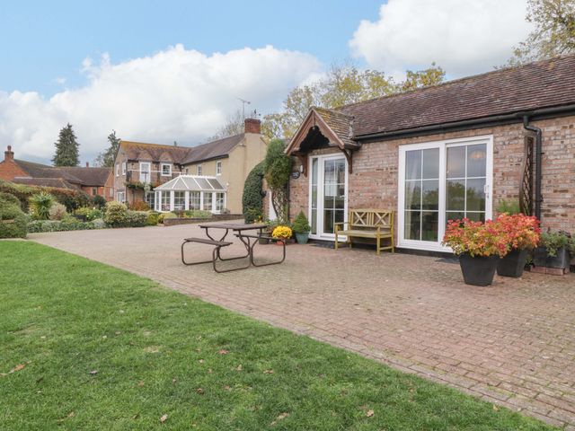 A garden with a dining table and chairs at Dovecote Cottage in Corse near Gloucester
