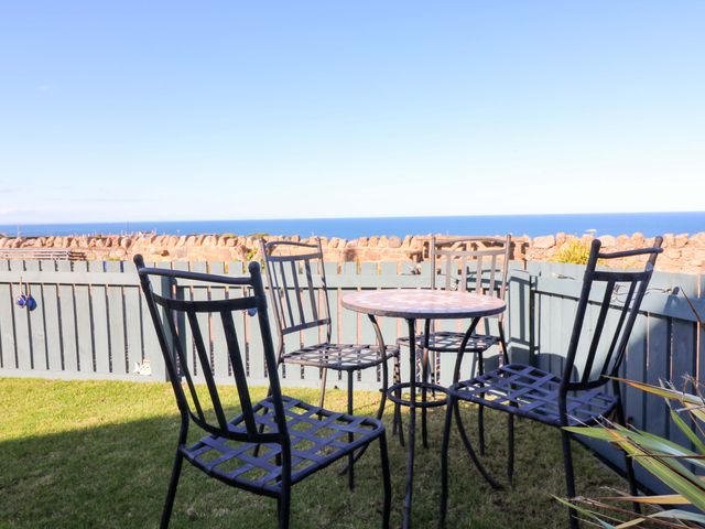 A garden with table and chairs overlooking the sea at Bridle Cottage in Cockburnspath