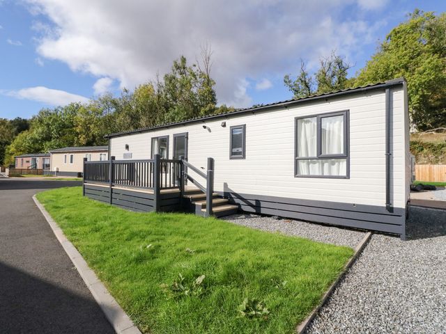 A mobile home with a deck and steps at Altair Lodge