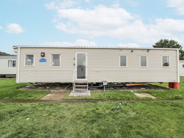 A mobile home with a front door and windows at Brynowen Holiday Park - Holiday Accommodation 22432 Borth