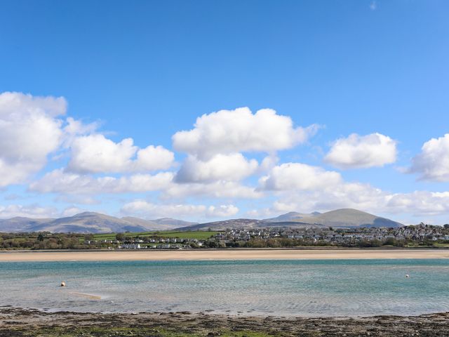 A scenic view of a beach and mountains at Trigfa in Brynsiencyn near Llanfairpwllgwyngyll