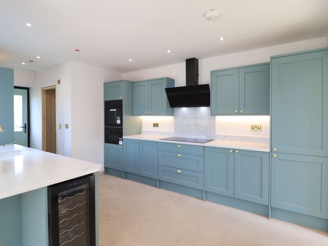 A kitchen with cabinets and appliances at New build at Tyn Pwll Llanfairpwllgwyngyll