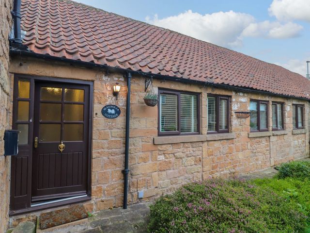 An entrance with a brown door and windows at Magnolia Cottage Nottingham