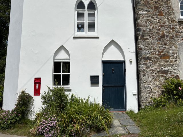 A white building with a blue door and red postbox at Old Sunday School Welcombe