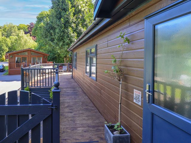 An outdoor view of a wooden house with decking and a planter at Evermore Lodge, 48 Calgarth Park, White Cross Bay, Windermere