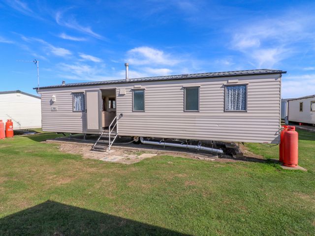 A caravan with steps and windows at Luisa Family Caravan St. Osyth