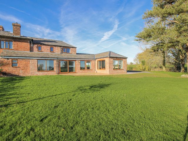 A house with large windows and a manicured garden at Garden Cottage in Cockshutt