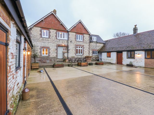 An outdoor area with a building, parking space, tables and chairs at The Farmhouse in Whitchurch, Buckinghamshire