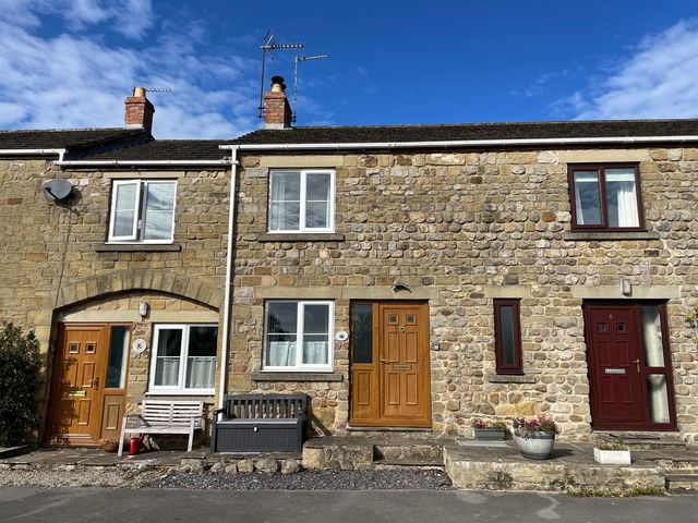 A stone facade with front doors and windows at Tyg Cottage Masham