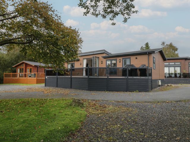 A house with a deck and trees in the outdoor area at 7 Lake View Windermere